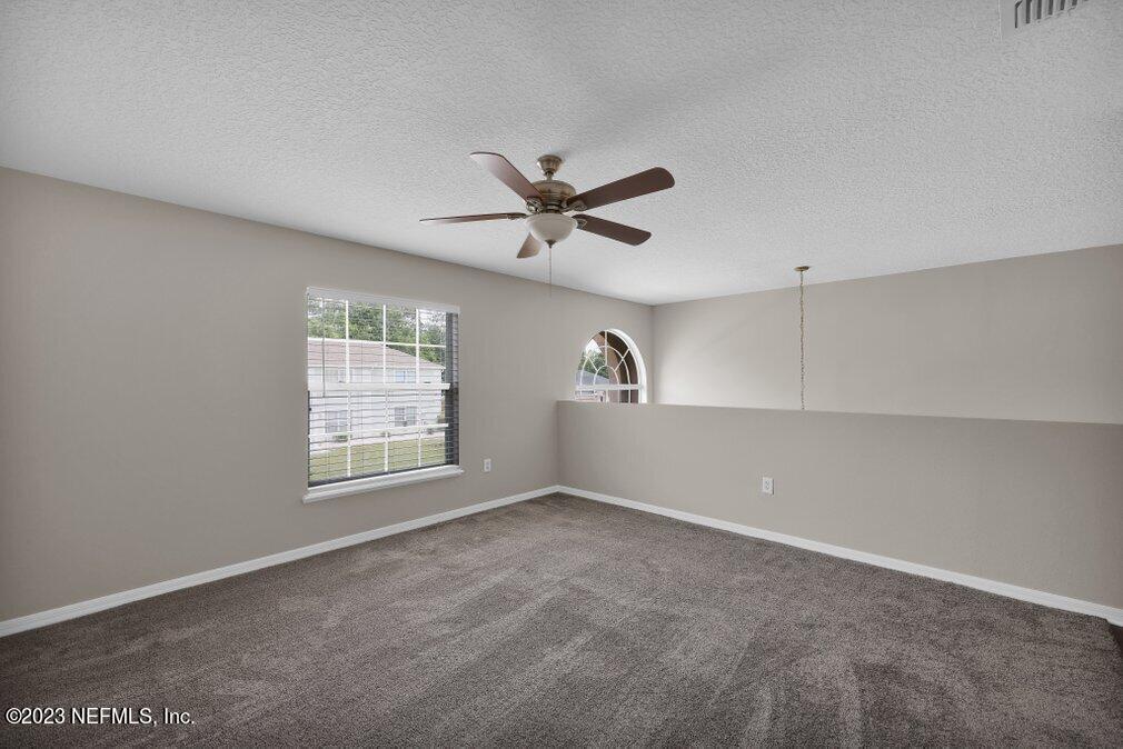 12070 Chester Creek Road Jacksonville, FL 32218 - Photo 27 of 45 an empty room with ceiling fan and windows
