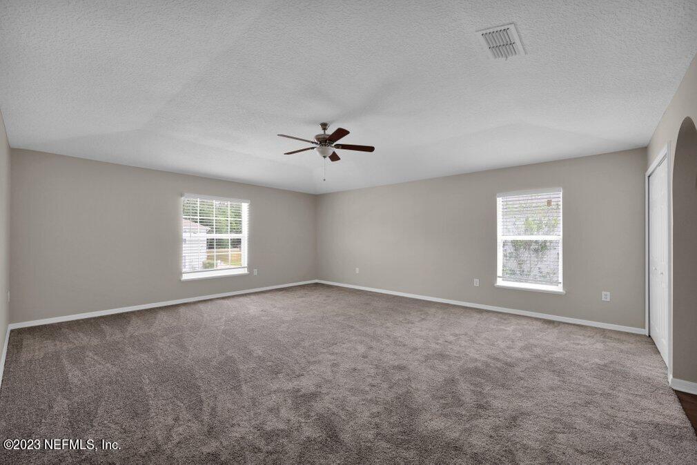 12070 Chester Creek Road Jacksonville, FL 32218 - Photo 28 of 45 an empty room with windows and ceiling fan view