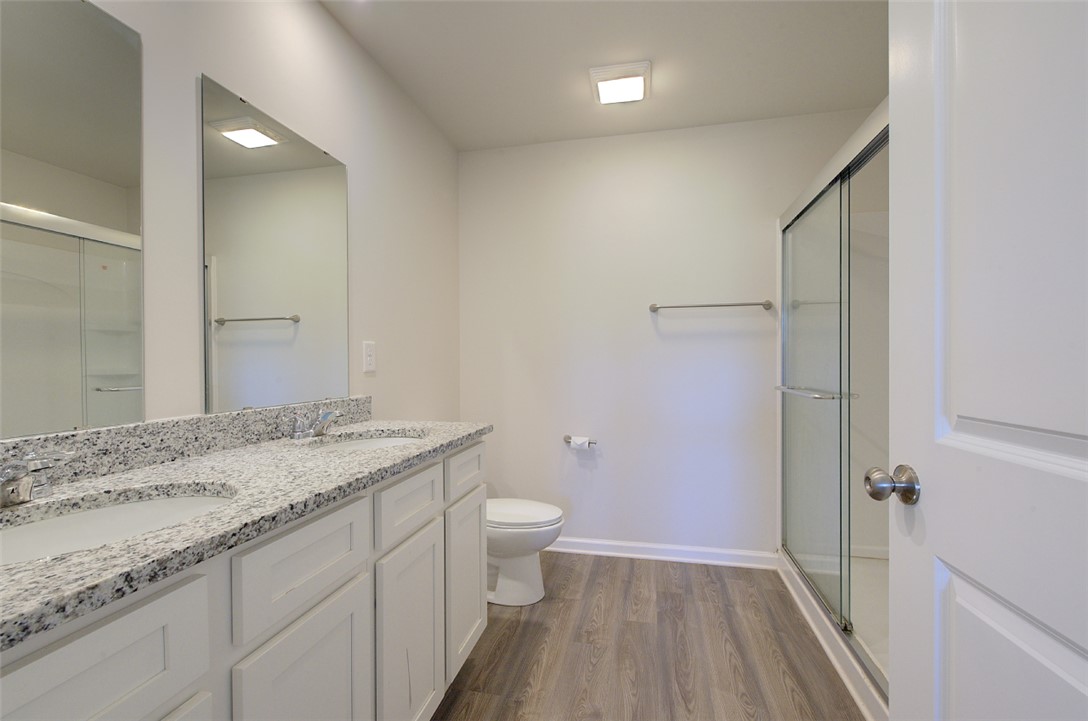 408 Chadwick Lane Walhalla, SC 29691 - Photo 17 of 44 Double vanity with stone counters and a spacious glass-enclosed shower elevate this bathroom.