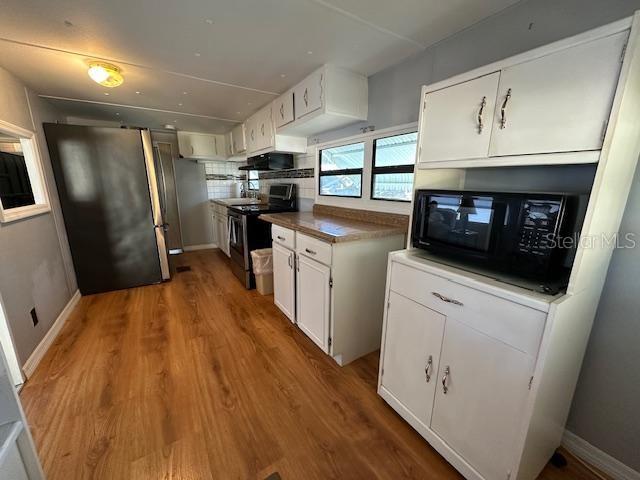 9486 Gray Fox Drive Weeki Wachee, FL 34613 - Photo 11 of 43 a kitchen with stainless steel appliances a refrigerator a sink a stove top oven a refrigerator and dishwasher