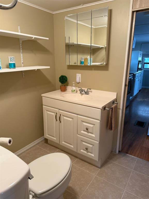 9486 Gray Fox Drive Weeki Wachee, FL 34613 - Photo 16 of 43 a utility room with a sink a toilet and a mirror