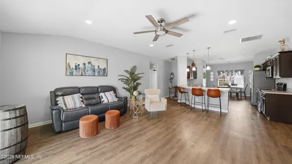 a living room with furniture and a flat screen tv with wooden floor