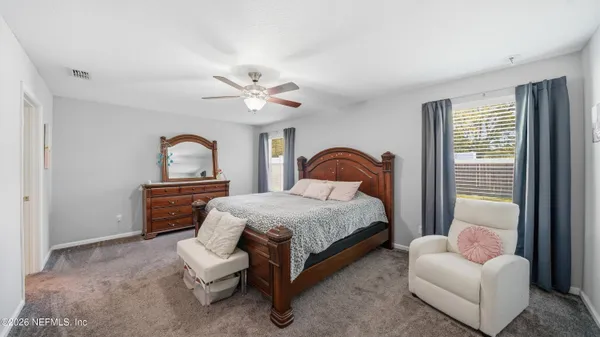 a spacious bedroom with a bed and a chandelier