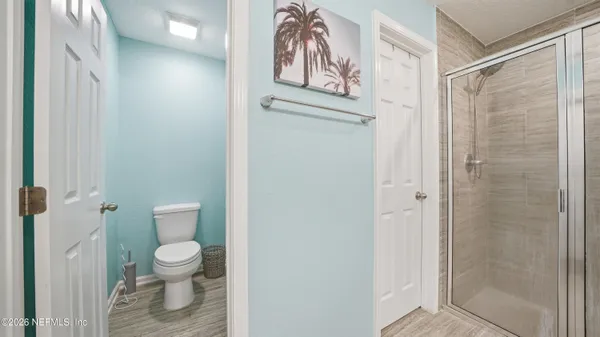 a bathroom with a granite countertop sink two mirror and a shower