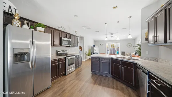 a large kitchen with a wooden floor and a refrigerator