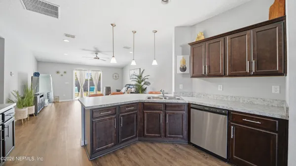 a kitchen with stainless steel appliances granite countertop wooden floors and sink