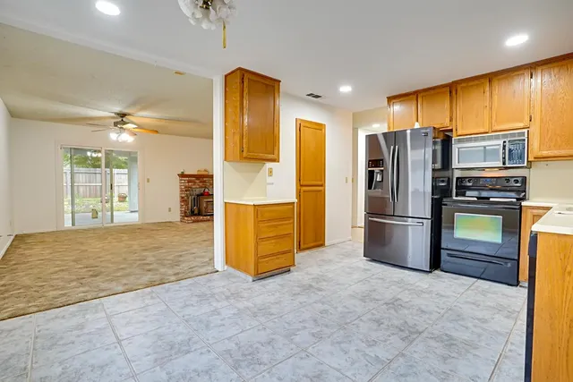 a view of kitchen with refrigerator cabinets and furniture