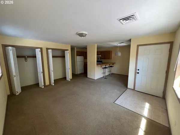 a view of a livingroom with furniture and a refrigerator