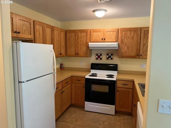 a kitchen with a stove refrigerator and a sink