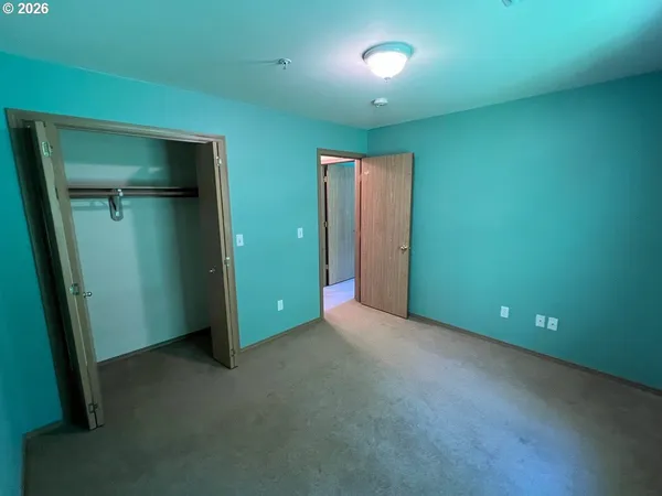 an empty room with closet and mirror