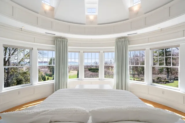 a bedroom with a large bed and large windows
