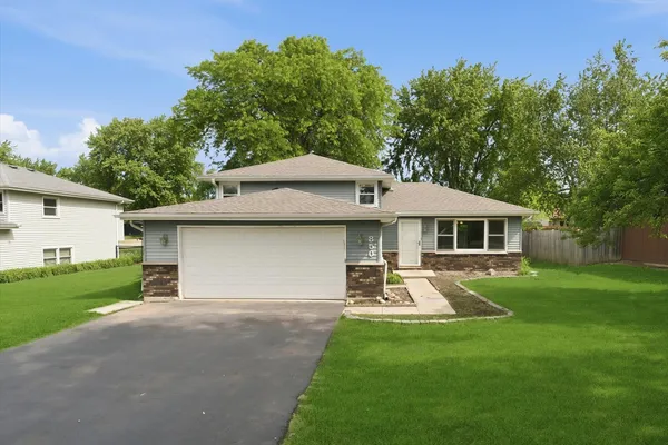 a front view of a house with a yard garage and outdoor seating
