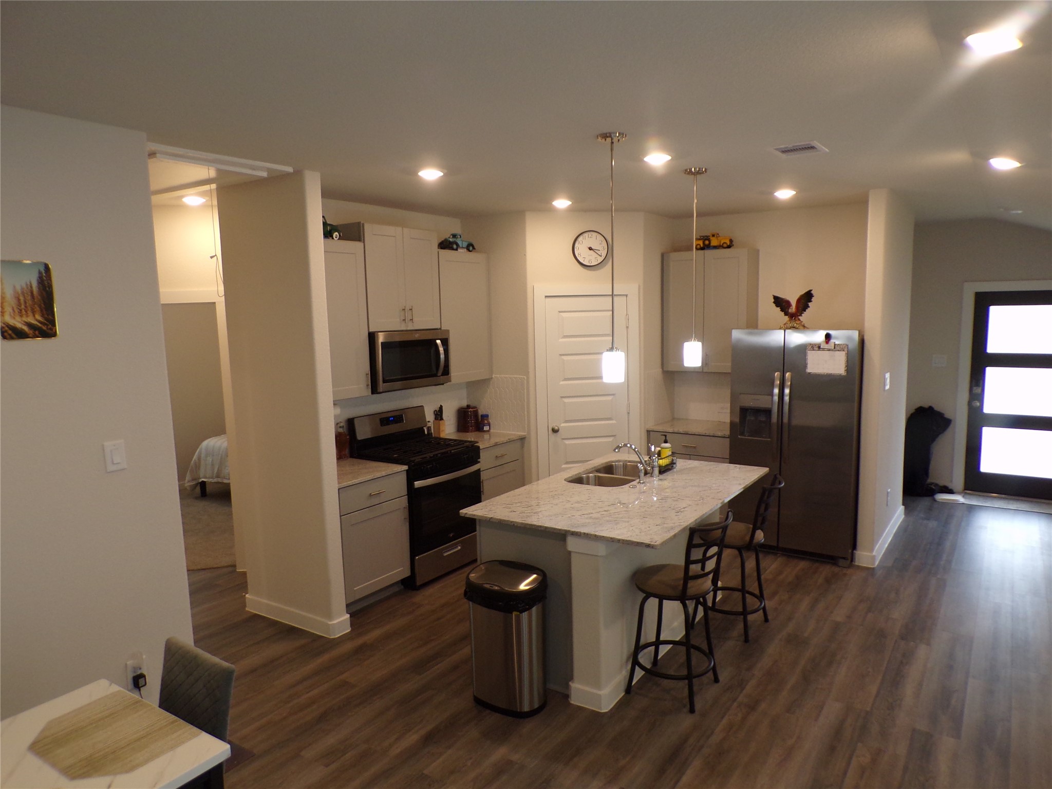 15419 Dapple Blf Lane Conroe, TX 77302 - Photo 3 of 19 a kitchen with stainless steel appliances granite countertop a refrigerator a stove top oven a sink dishwasher and a dining table with wooden floor
