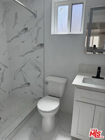 a white toilet sitting next to a bathroom sink