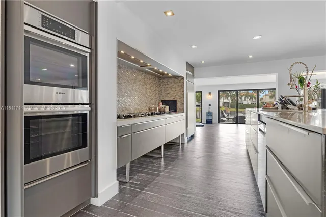 a living room with furniture a large window and wooden floor