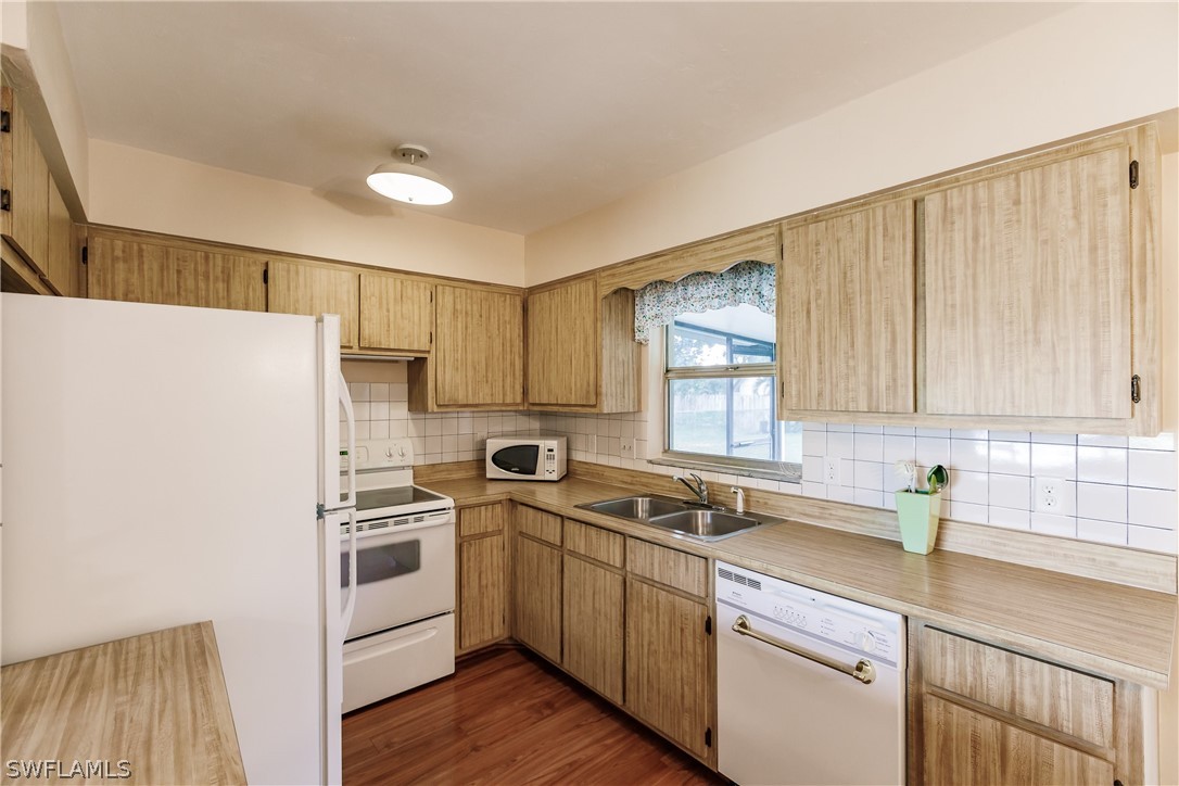 18506 Geranium Road Fort Myers, FL 33967 - Photo 12 of 32 a kitchen with a sink a refrigerator and cabinets
