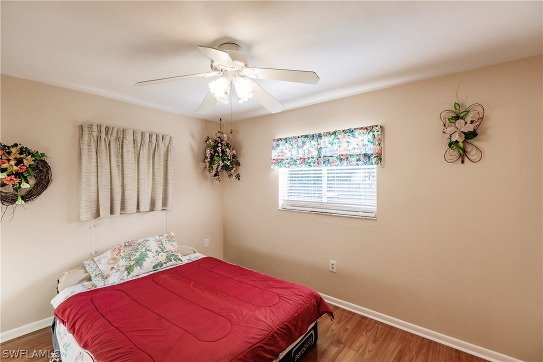 18506 Geranium Road Fort Myers, FL 33967 - Photo 14 of 32 a bedroom with a bed and a chandelier