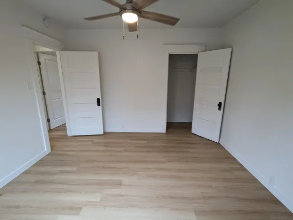 a view of an empty room with wooden floor
