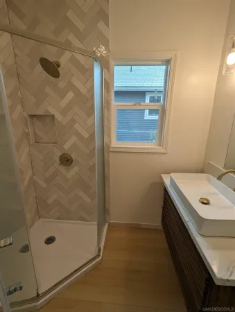 a bathroom with a shower a sink and a mirror