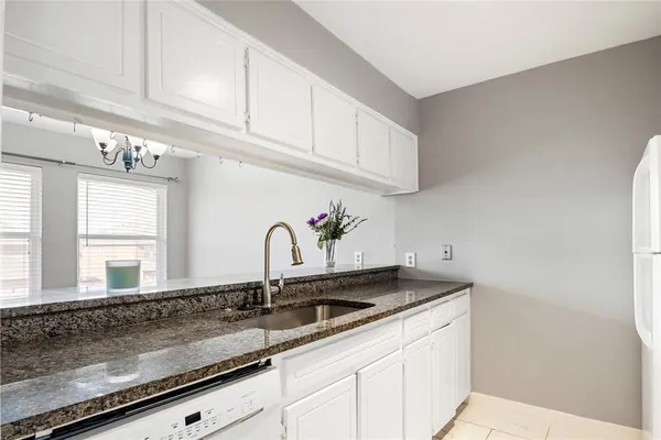 a kitchen with granite countertop a sink and cabinets