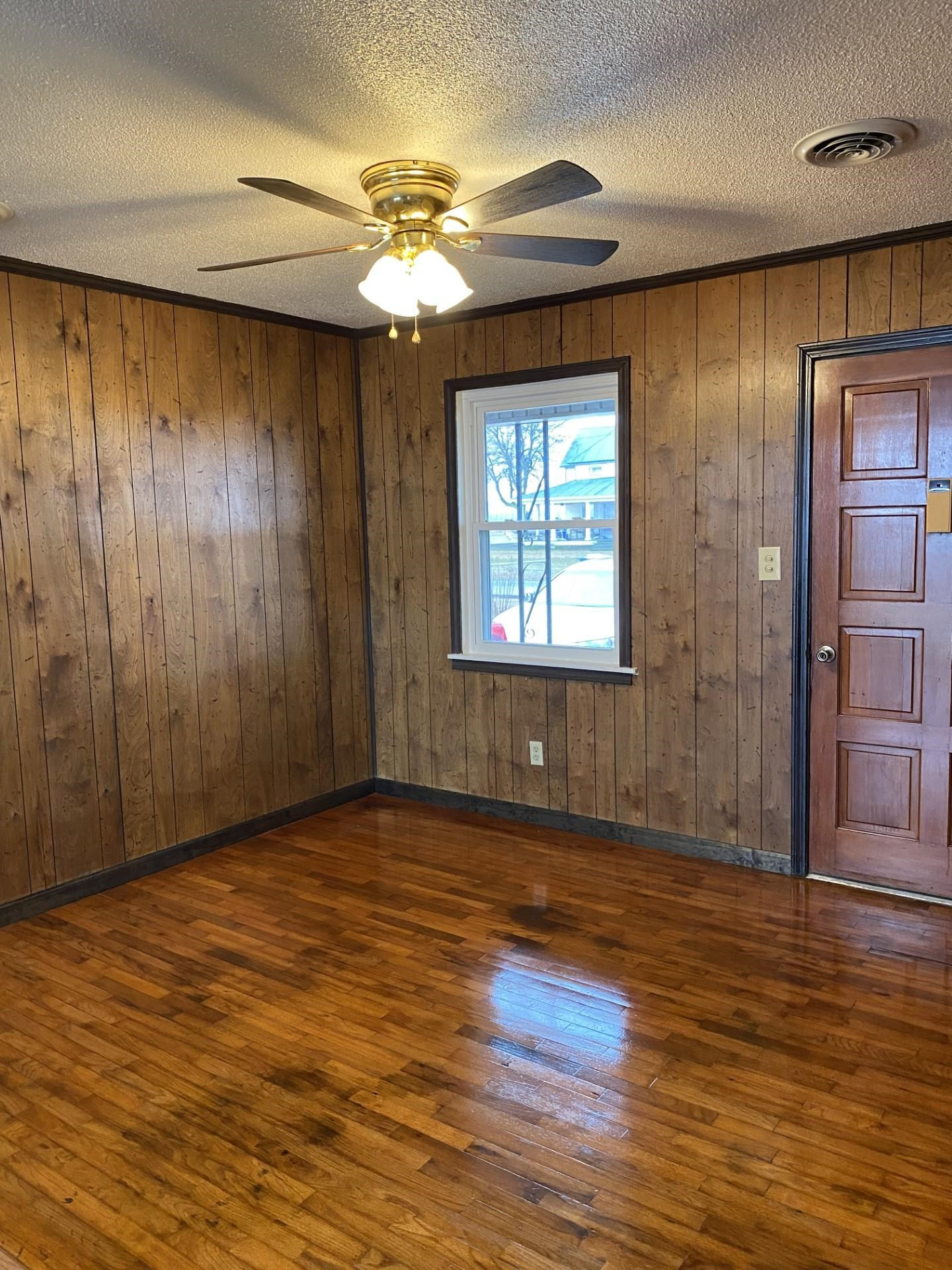 570 Dillard Street Ridgely, TN 38080 - Photo 10 of 10 an empty room with wooden floor chandelier fan and windows