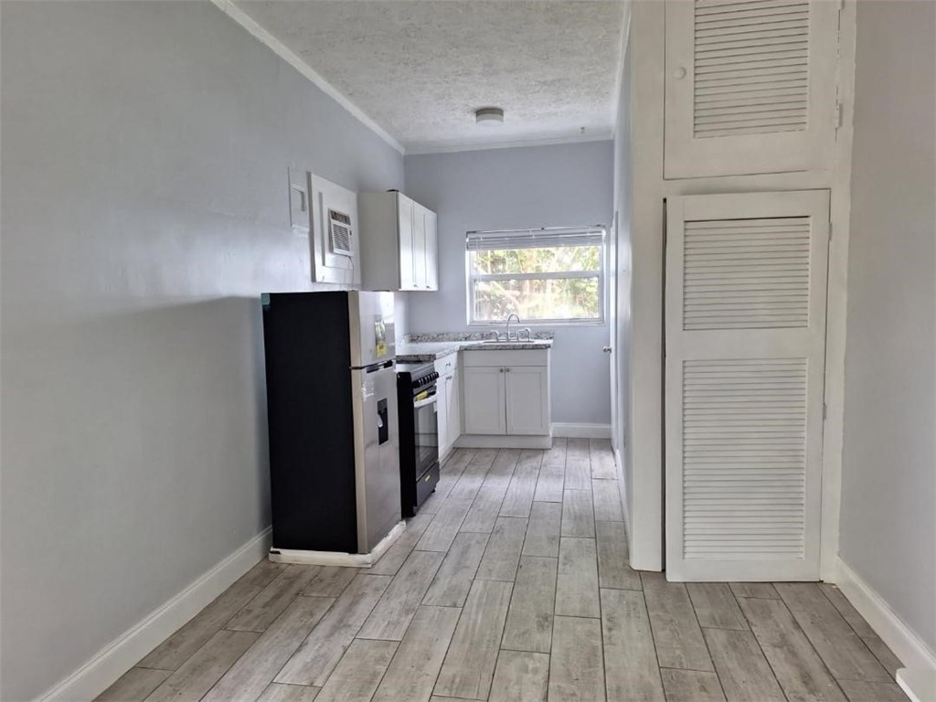 9150 44th Avenue, Unit 15 Sebastian, FL 32958 - Photo 17 of 21 a kitchen with a refrigerator and wooden floor