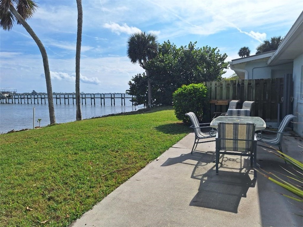 9150 44th Avenue, Unit 15 Sebastian, FL 32958 - Photo 3 of 21 a view of a patio with table and chairs and wooden fence