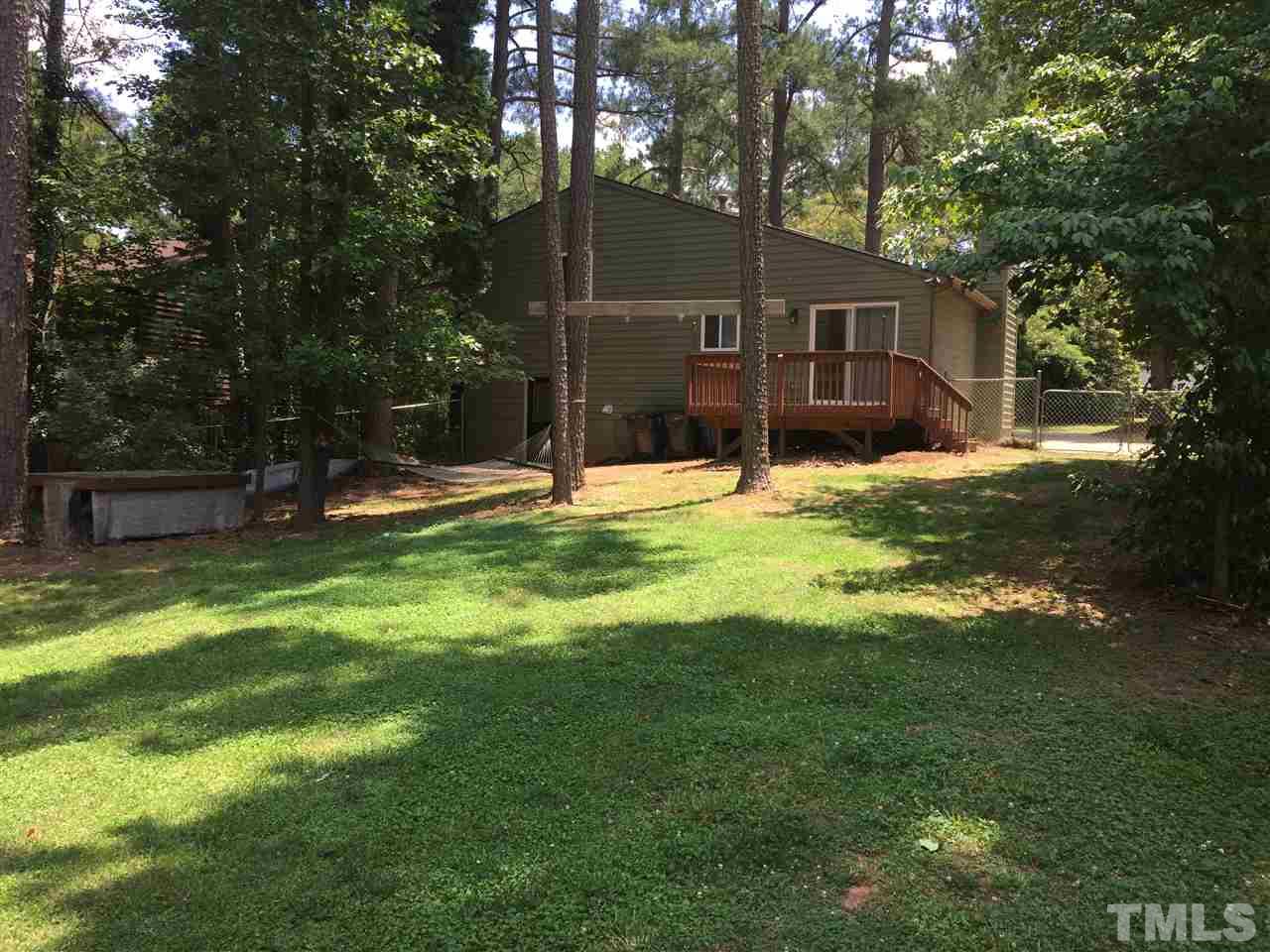 Giant fenced back yard with shed and fire pit.