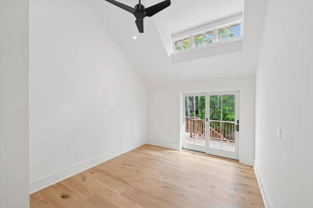 an empty room with a window and a ceiling fan