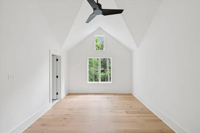 a view of empty room with wooden floor and windows