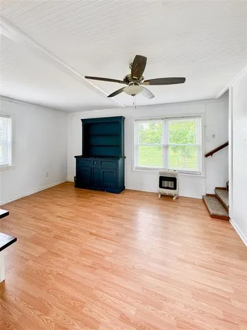 a view of empty room with wooden floor and windows