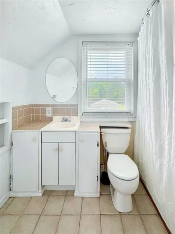 a bathroom with a toilet sink vanity and mirror