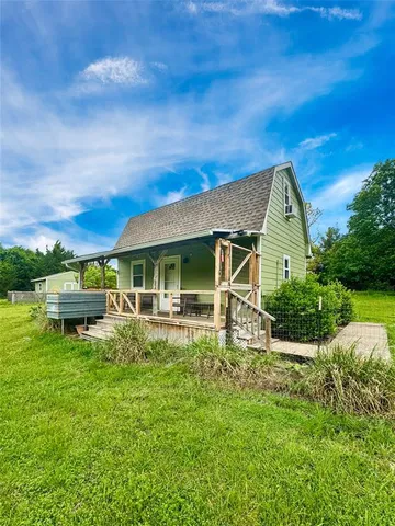 a view of house with backyard and outdoor seating