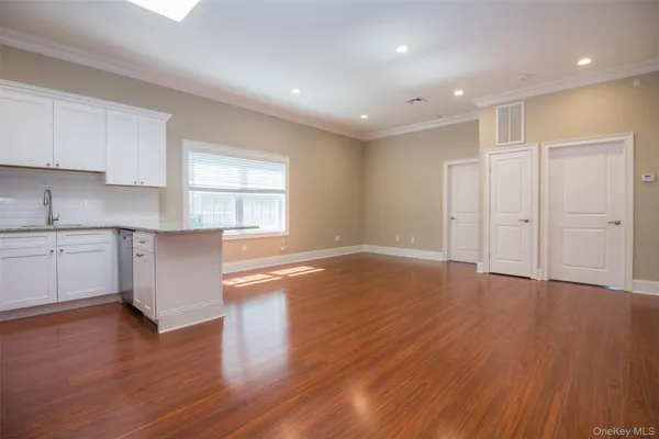 a view of a kitchen with wooden floor and a window