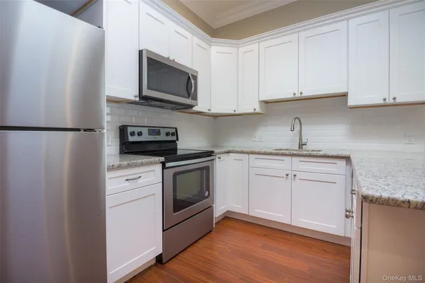 a kitchen with white cabinets stainless steel appliances and sink