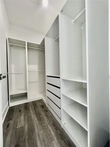 a view of walk in closet with empty racks