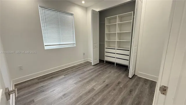 a view of a room with wooden floor and a window