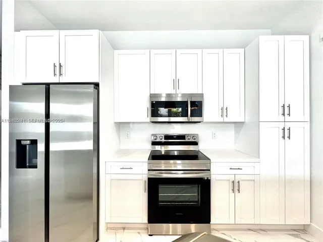 a kitchen with stainless steel appliances a stove a refrigerator and cabinets
