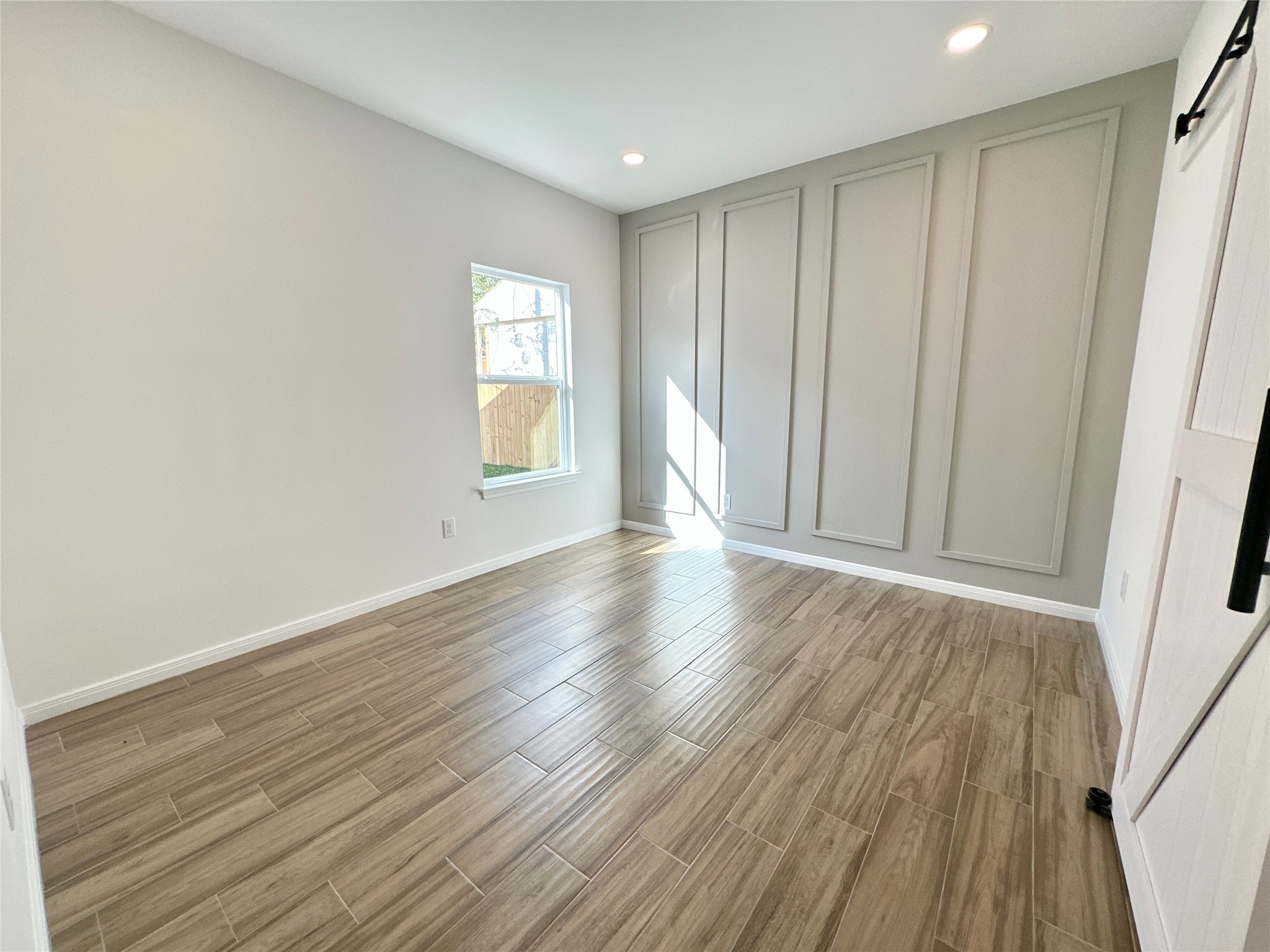 11557 Persimmon Street Willis, TX 77318 - Photo 11 of 19 a view of an empty room with wooden floor and a window