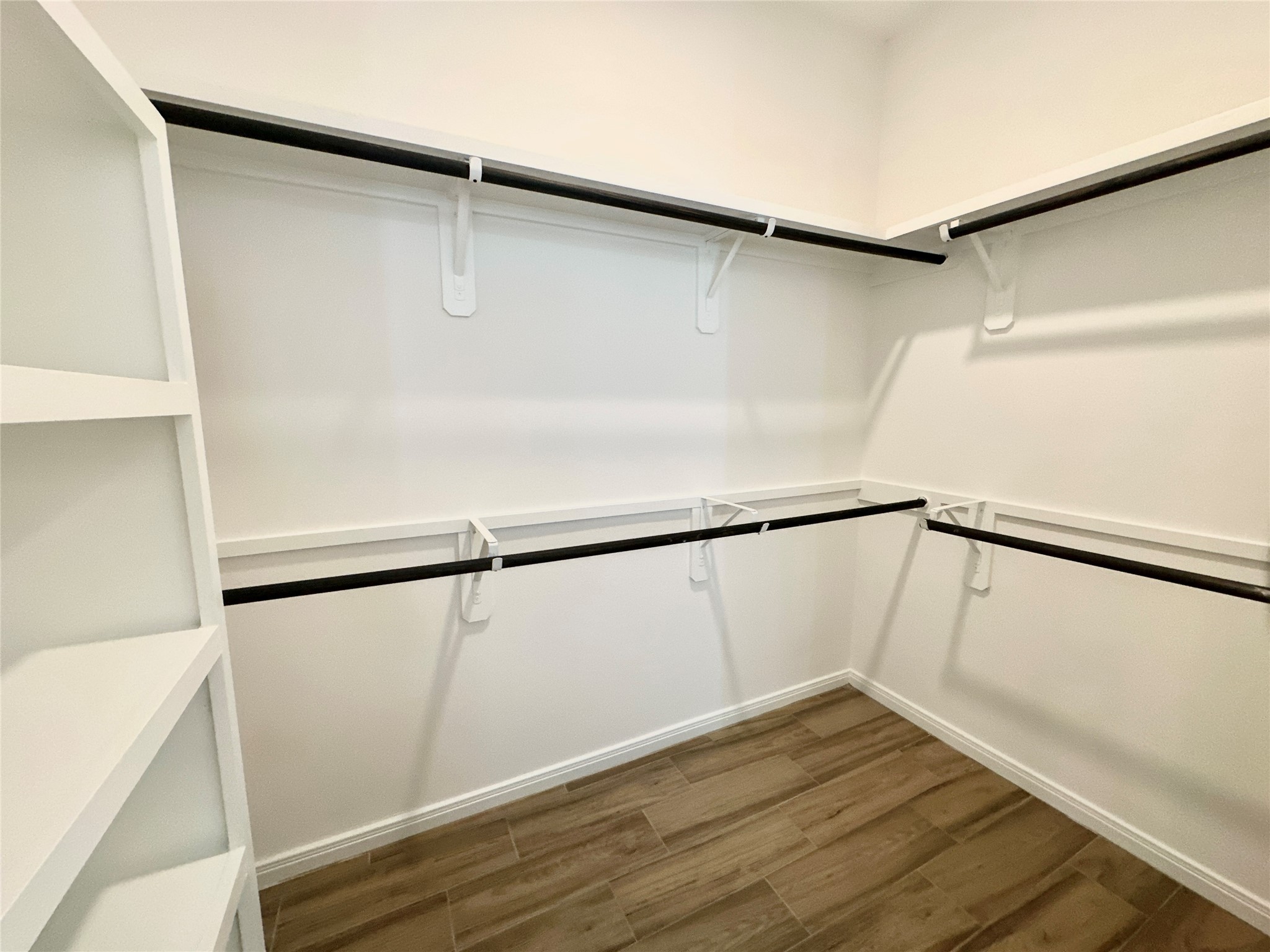 11557 Persimmon Street Willis, TX 77318 - Photo 13 of 19 a view of walk in closet with wooden floor