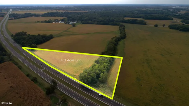 an aerial view of a house with a yard and lake view