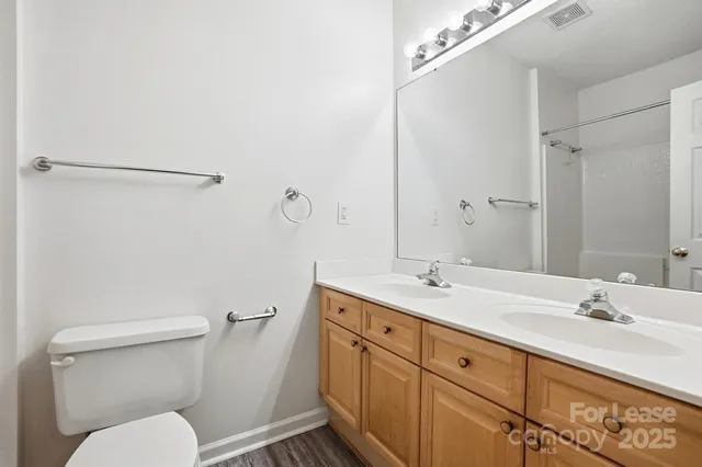 a bathroom with a granite countertop toilet sink and mirror