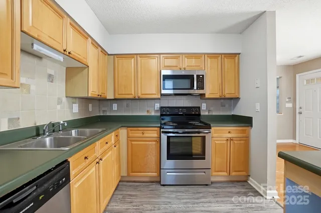 a kitchen with stainless steel appliances granite countertop a sink stove and microwave