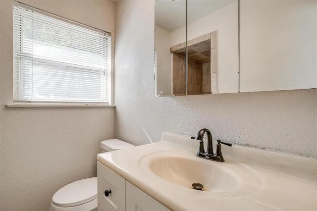 a bathroom with a toilet sink and mirror