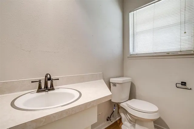 a bathroom with a toilet a sink and mirror
