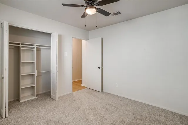 a view of an empty room with a ceiling fan