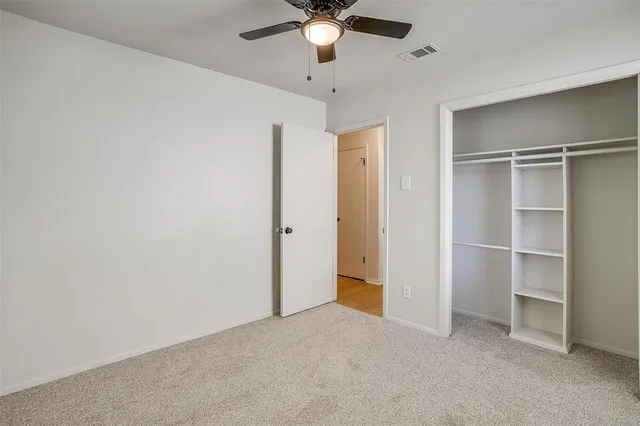 a view of an empty room with a ceiling fan