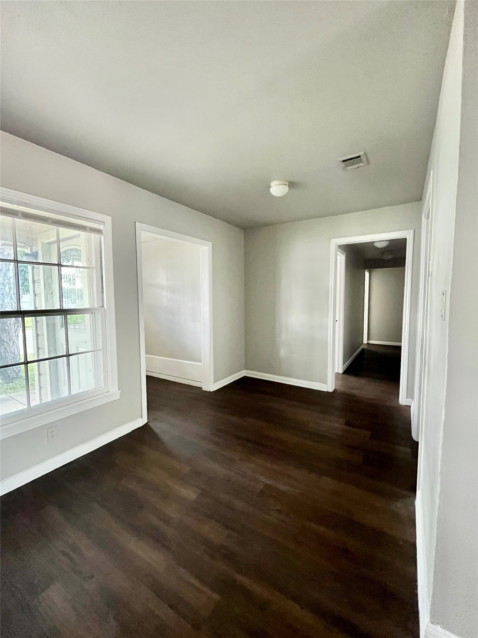 5101 Guadalupe Street, Unit A Austin, TX 78751 - Photo 11 of 28 Spare room with baseboards and dark wood-type flooring