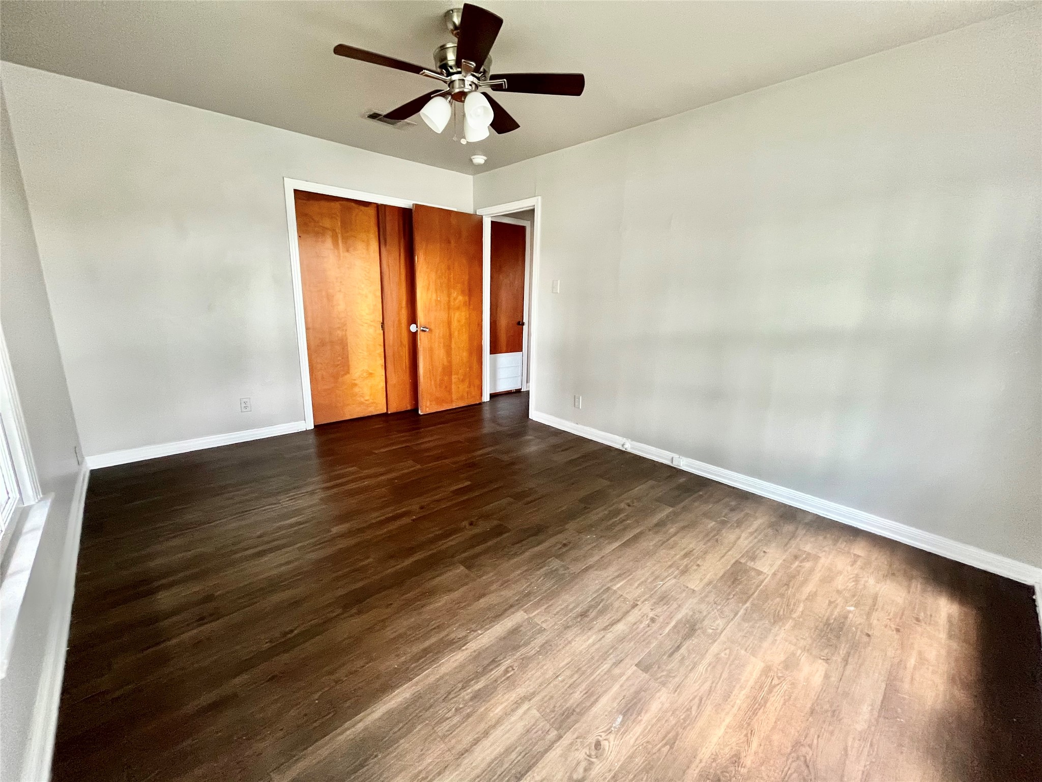 5101 Guadalupe Street, Unit A Austin, TX 78751 - Photo 18 of 28 Unfurnished bedroom with dark wood-style floors, a closet, and ceiling fan