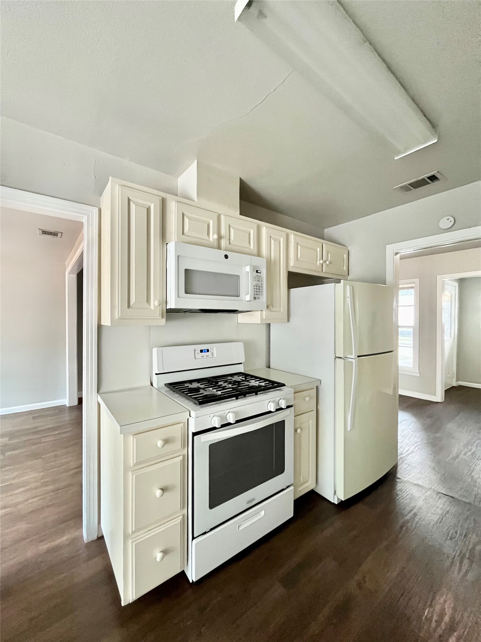5101 Guadalupe Street, Unit A Austin, TX 78751 - Photo 7 of 28 Kitchen with white appliances, dark wood-style flooring, light countertops, and cream cabinetry